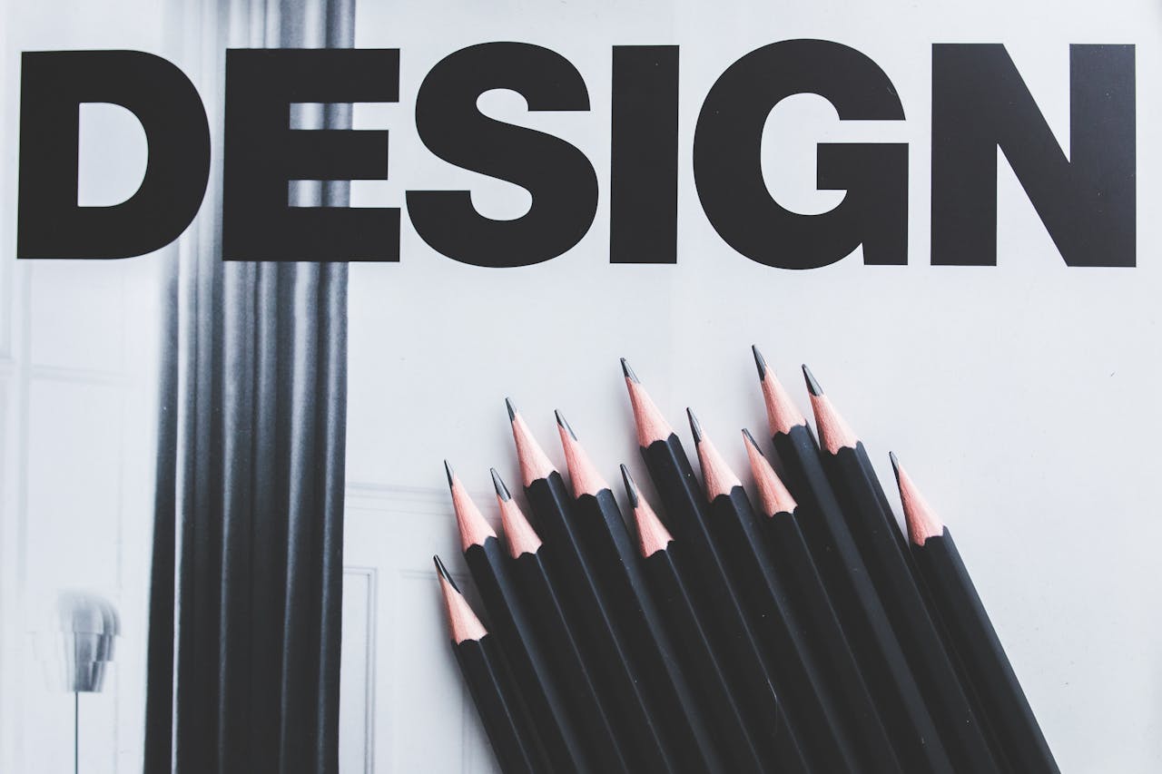 discover Black pencils arranged creatively next to large typography 'DESIGN'.